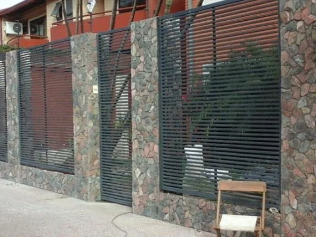 Fachada con revestimiento de piedra y celosías